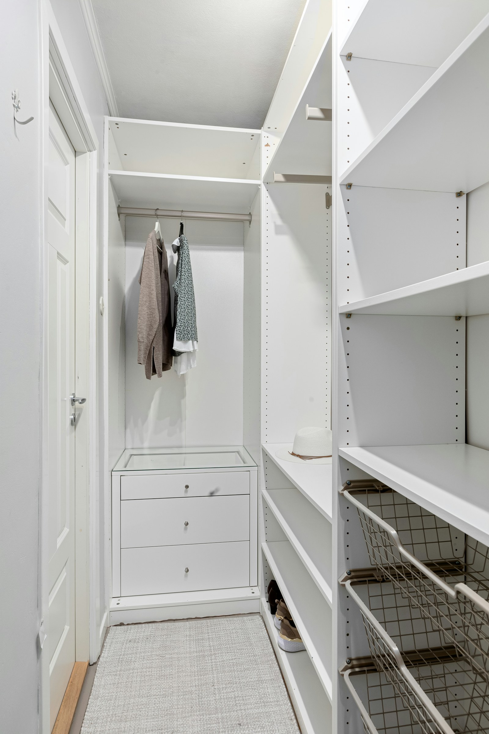 Closet branco com prateleiras e varões integrados